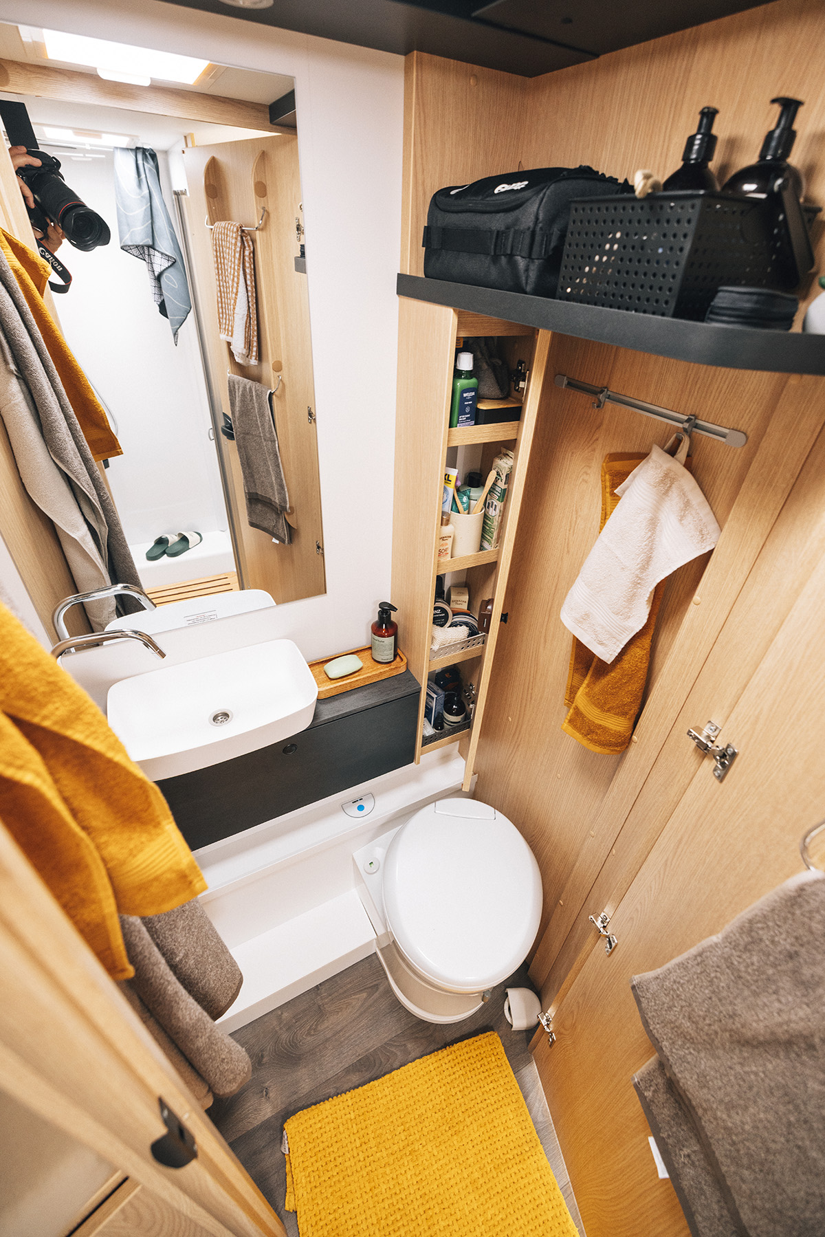 Compact bathroom in the Sunlight UNLTD T camper with cassette toilet, sink and storage shelves for Unlimited Sunlight travel.