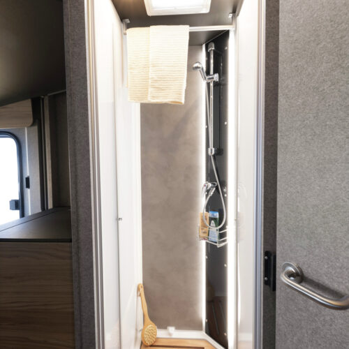 Compact shower cubicle with skylight and shower caddy in the Dethleffs Trend I 7027 motorhome bathroom.