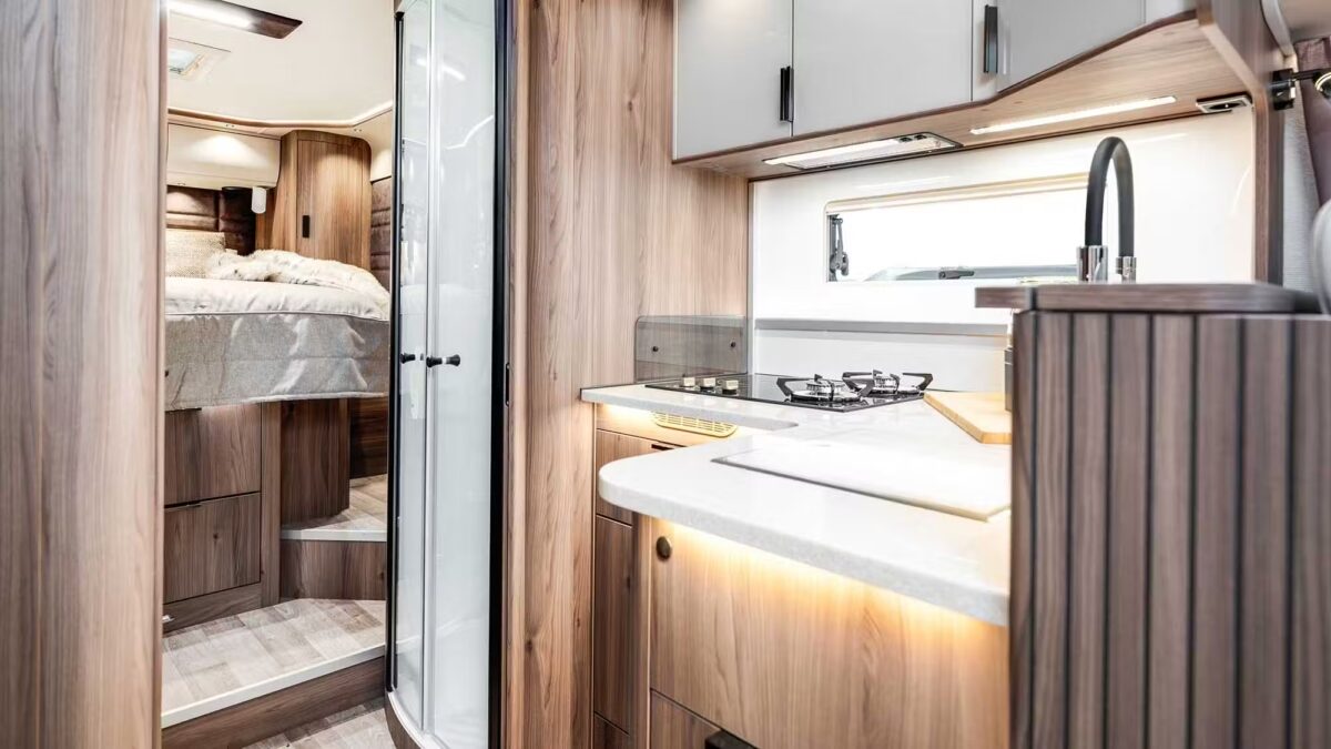 Kabe Imperial 4x4 motorhome interior showing kitchen with hob, sink and view through to bedroom and shower cubicle