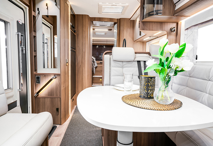 Kabe Imperial Ri810 LGB interior with white dinette table, tulips and wood-panelled cabinetry