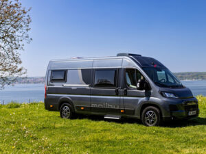 Malibu Relax campervan parked on grass by a lake, ideal exterior view for a Malibu Camping Guide.
