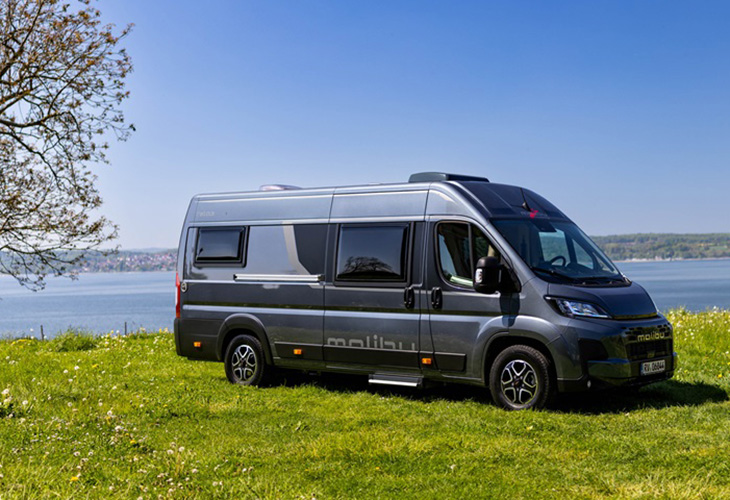 Malibu Relax campervan parked on grass by a lake, ideal exterior view for a Malibu Camping Guide.