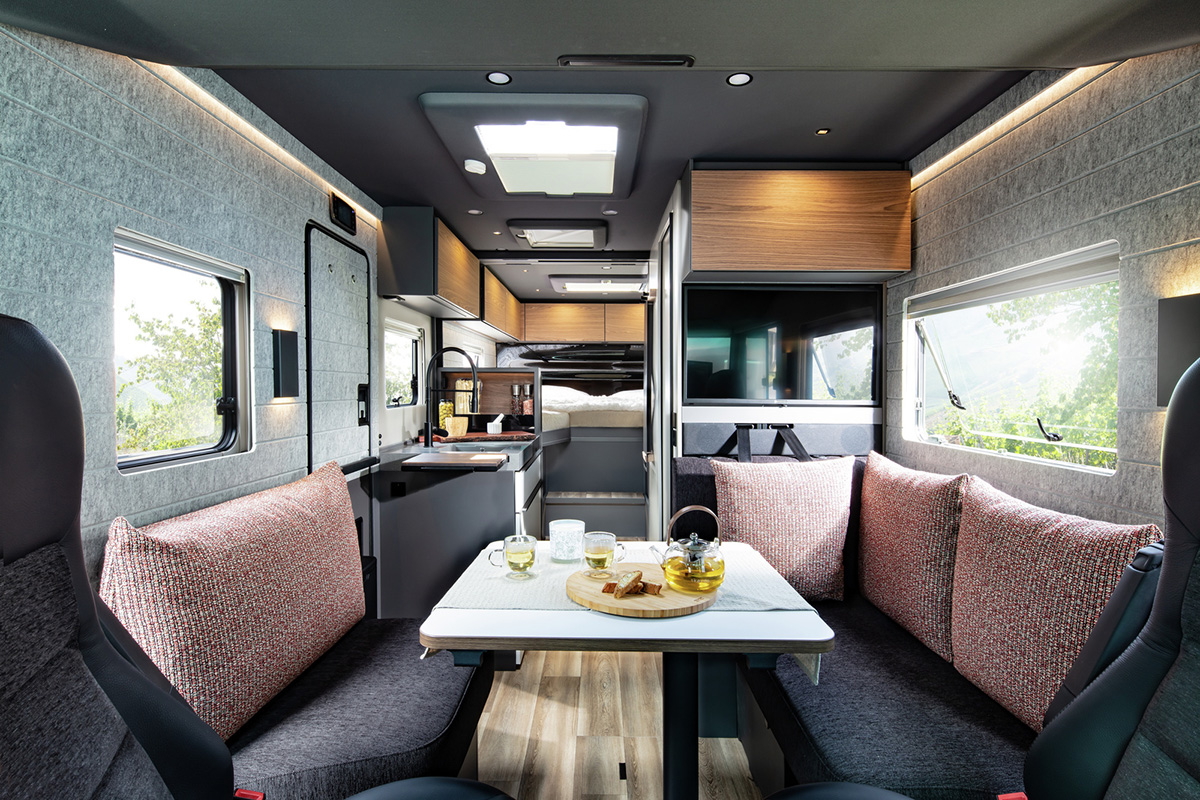 Niesmann+Bischoff iSmove 2027 interior with dinette seating, kitchenette, TV and skylight in campervan