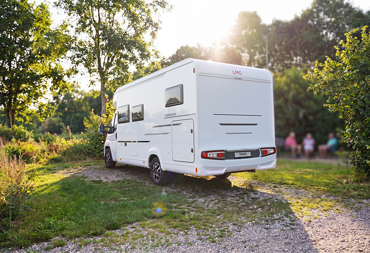 LMC Tracer motorhome with white chassis parked on gravel path in green landscape, part of LMC campers 2027 range
