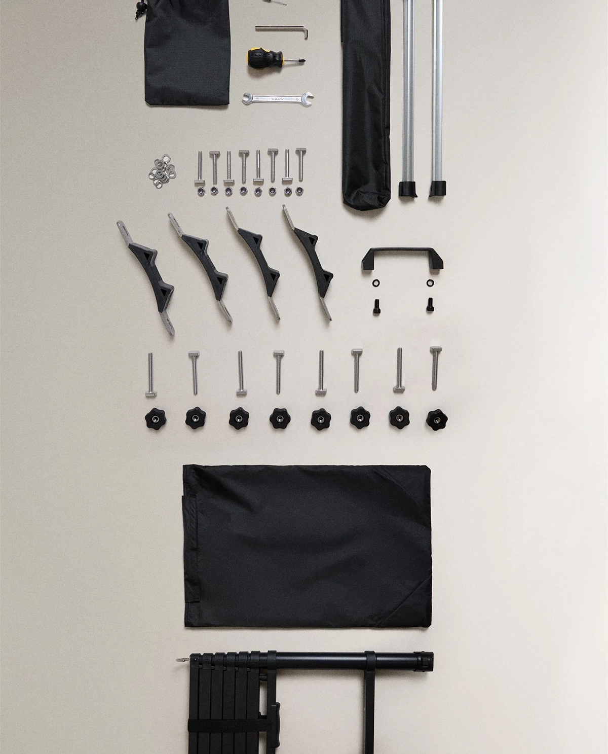 Zara Home rooftop tent assembly kit laid out flat, showing poles, brackets, screws, tools and carry bags