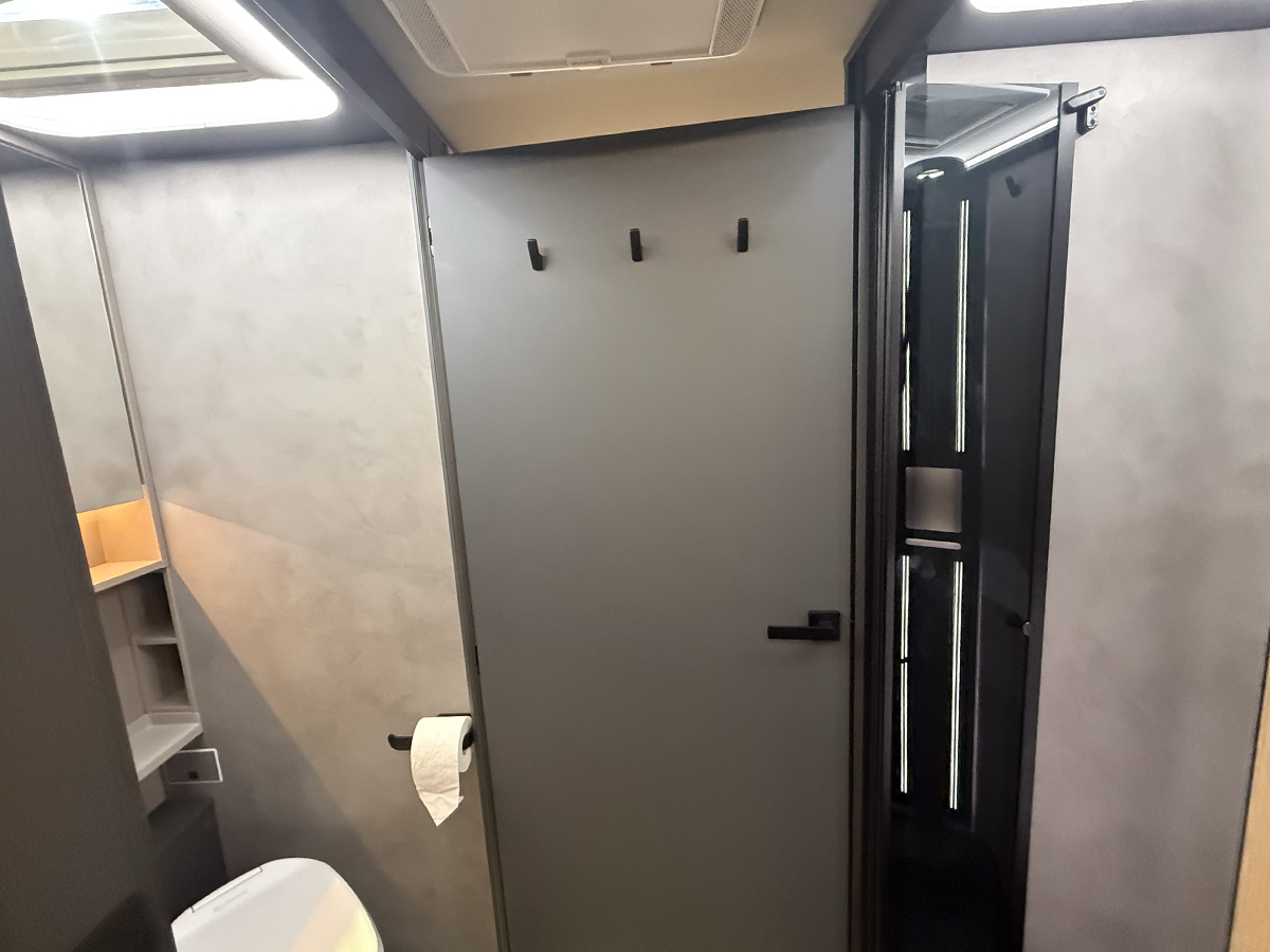 Frankia Noctra Liner bathroom with grey walls, toilet, mirror and separate shower cubicle