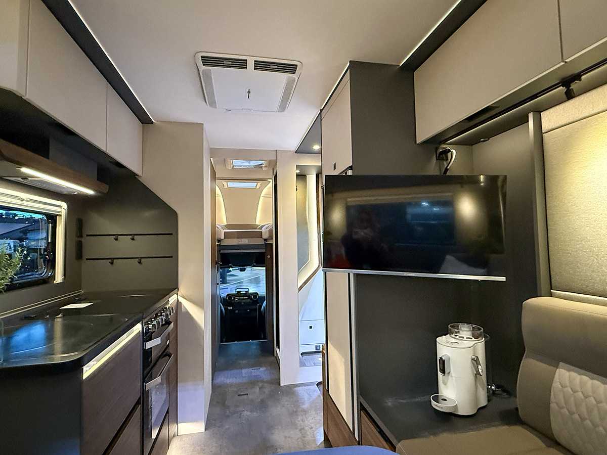 Dethleffs Graneo motorhome interior with kitchen, TV and view towards cab and alcove bed area