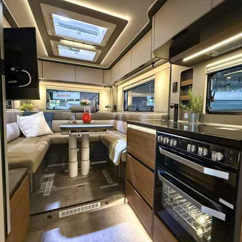 Dethleffs Graneo motorhome interior with U-shaped lounge seating and modern kitchen with oven and hob