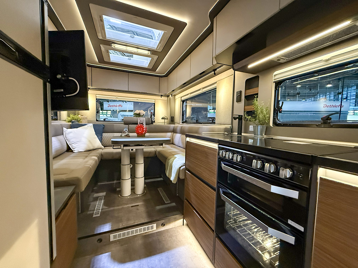 Dethleffs Graneo motorhome interior with U-shaped lounge seating and modern kitchen with oven and hob