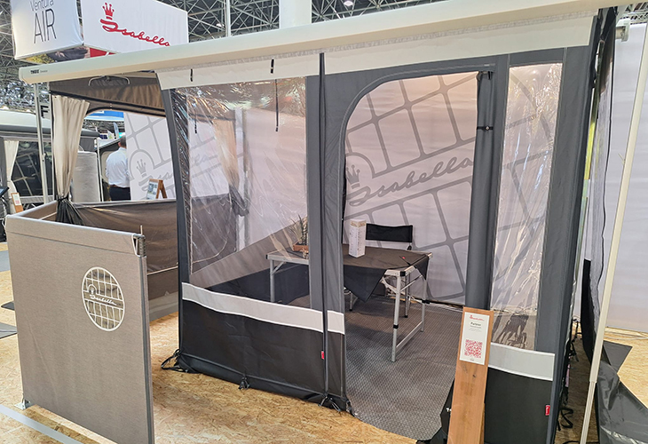 Isabella cassette awning display with mesh windows, table and chairs set up at trade show exhibition