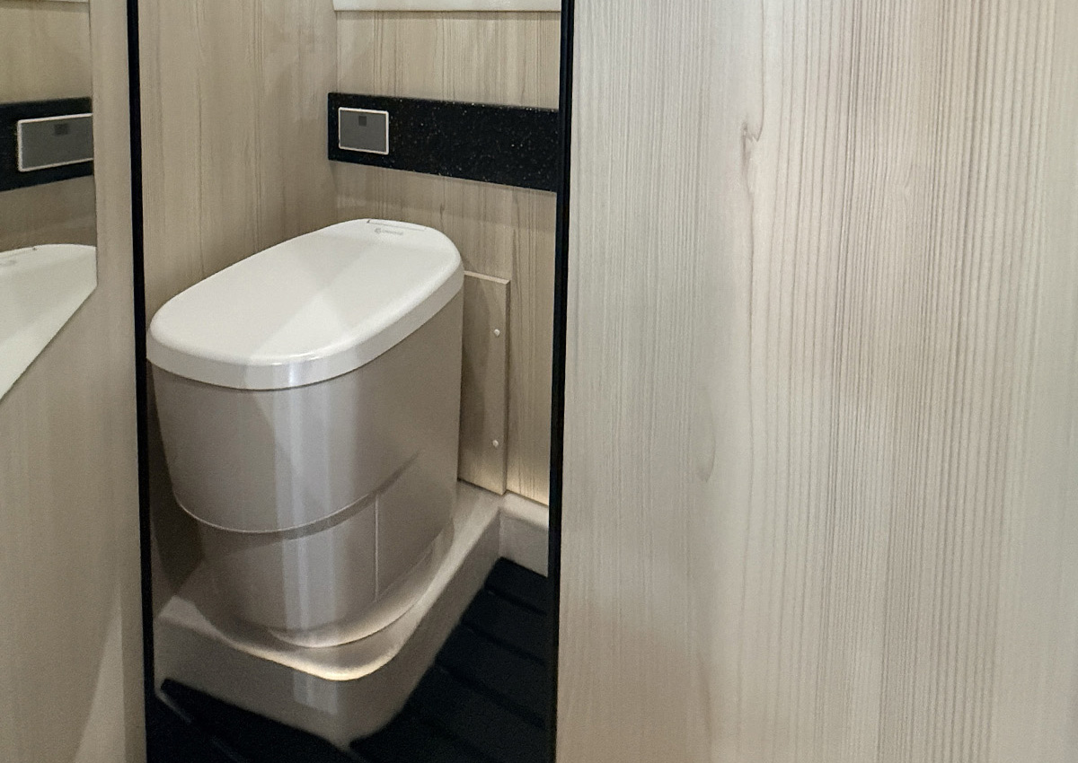 Cassette toilet with wood-panelled surround in the Toyota Innova Road Trip campervan bathroom