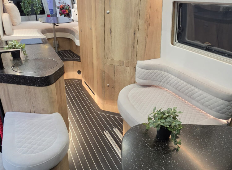 Toyota Innova Road Trip campervan interior showing lounge bench seating, wood cabinetry and compact kitchenette