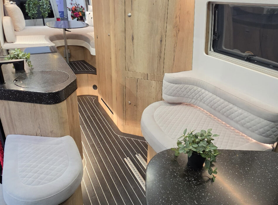Toyota Innova Road Trip campervan interior showing lounge bench seating, wood cabinetry and compact kitchenette