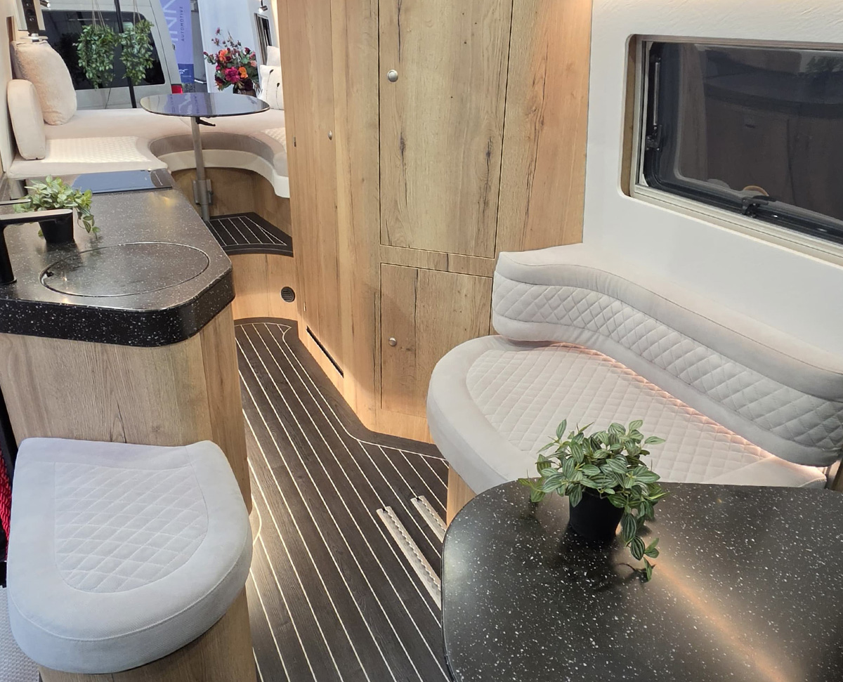 Toyota Innova Road Trip campervan interior showing lounge bench seating, wood cabinetry and compact kitchenette