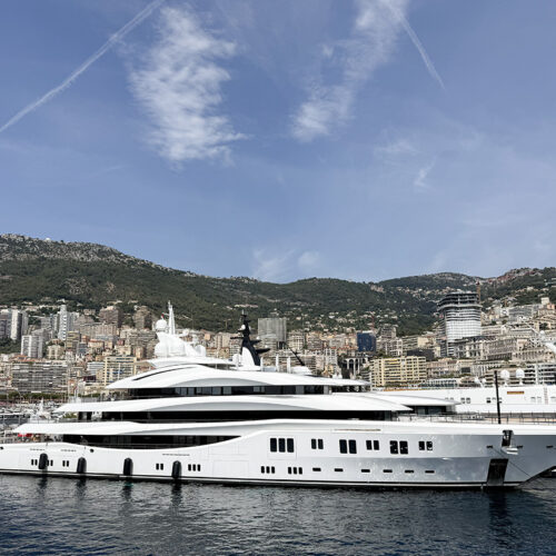 Luxury superyacht in Monaco harbour, with hillside cityscape backdrop, near Camping Parc Bellevue Cannes day trip route