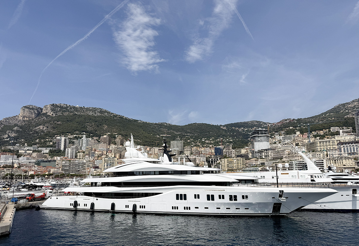 Luxury superyacht in Monaco harbour, with hillside cityscape backdrop, near Camping Parc Bellevue Cannes day trip route
