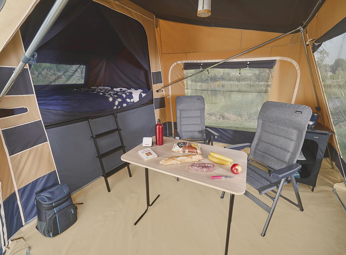 Jamet Offtrail folding trailer tent interior with elevated bed, dining table, camping chairs and cool box.