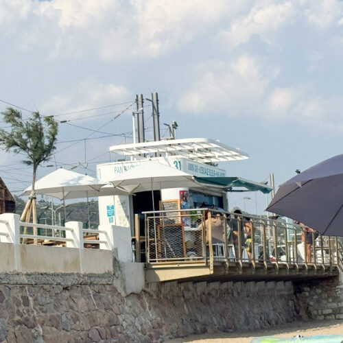 Beach kiosk "Pan Bagnat" on Cannes boulevard, near Camping Parc Bellevue, with sun umbrellas and seaside promenade.