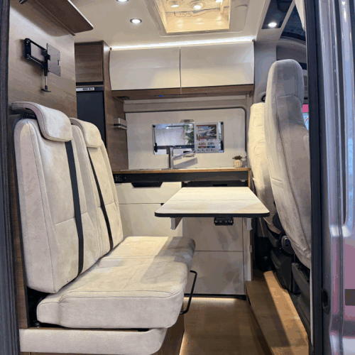 Rapido V64 camper van dinette with fold-out table and beige upholstered seating