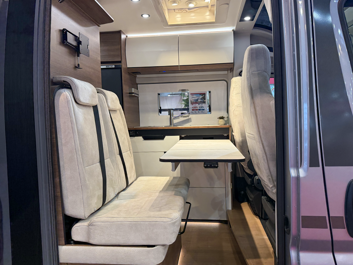 Rapido V64 camper van dinette with fold-out table and beige upholstered seating