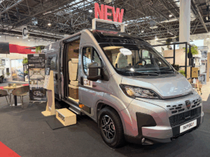 Rapido V64 camper van exterior on show floor, silver Fiat Ducato base with sliding door open, showing interior