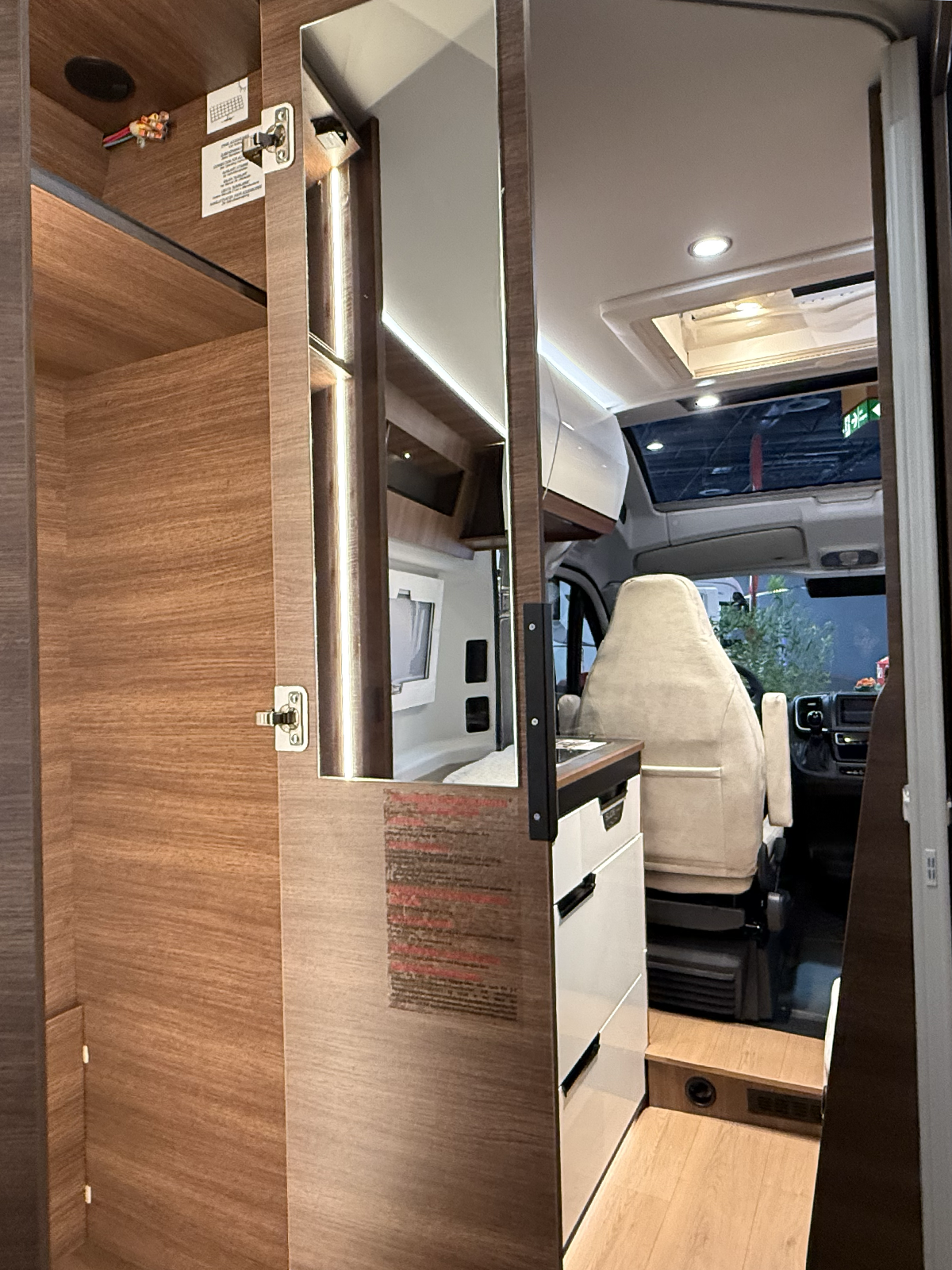Rapido V64 wardrobe interior with mirror, showing view through to cab and driver's seat