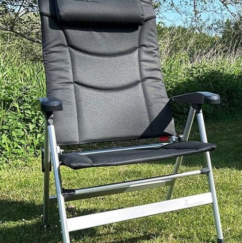 Isabella Thor XL folding camping chair with padded headrest and armrests, set up on grass outdoors.