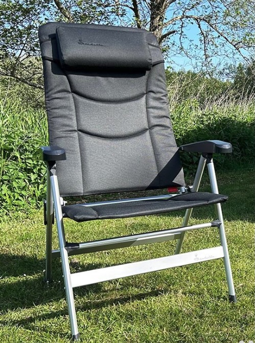 Isabella Thor XL folding camping chair with padded headrest and armrests, set up on grass outdoors.