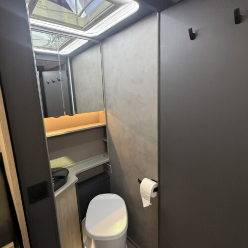 Compact bathroom in the Frankia Noctra Liner with skylight, toilet, sink and toilet roll holder.