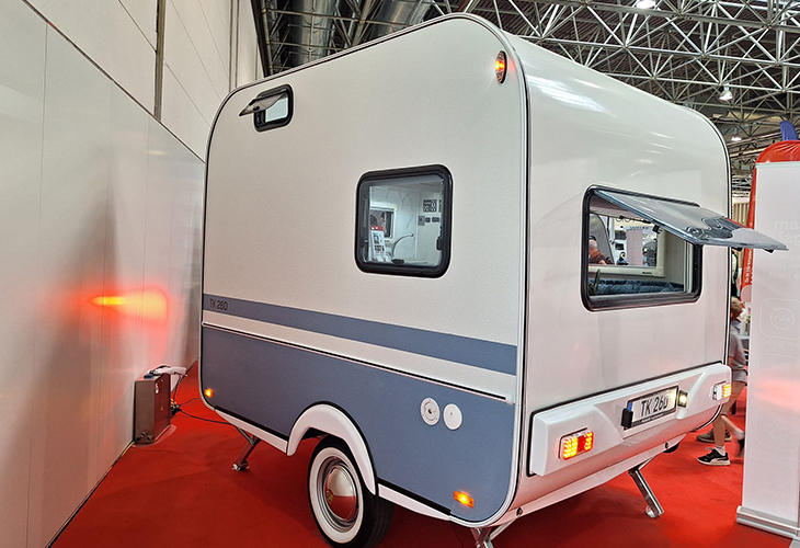Tosbiq TK 260 eye-catching compact caravan in white and blue, rear view, displayed at Caravan Salon