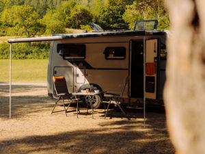 Bürstner Signature Mercedes motorhome with awning extended and camping chairs set up outside the open door.