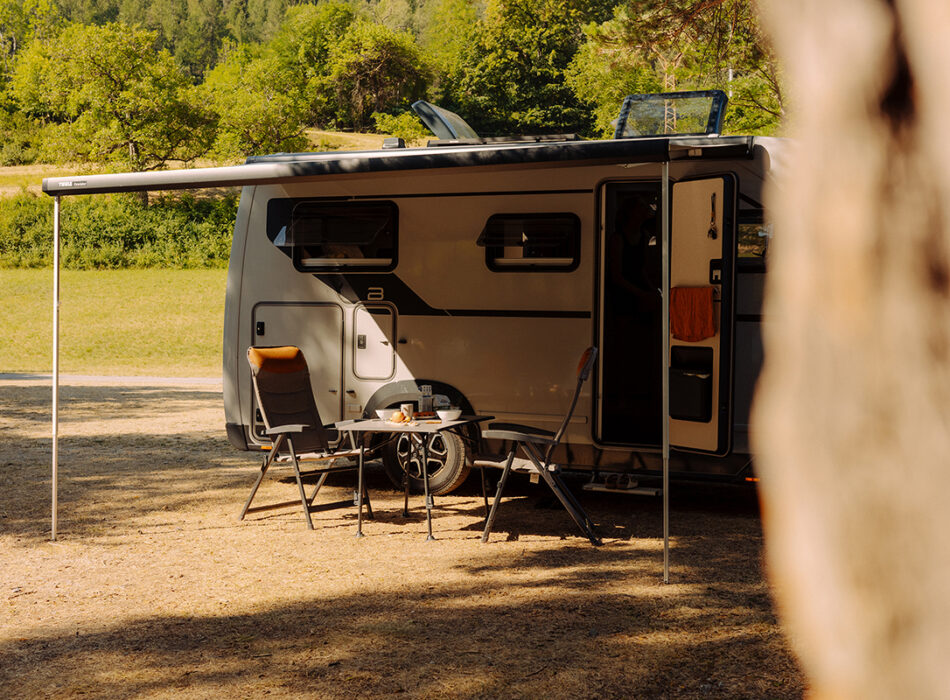 Bürstner Signature Mercedes motorhome with awning extended and camping chairs set up outside the open door.