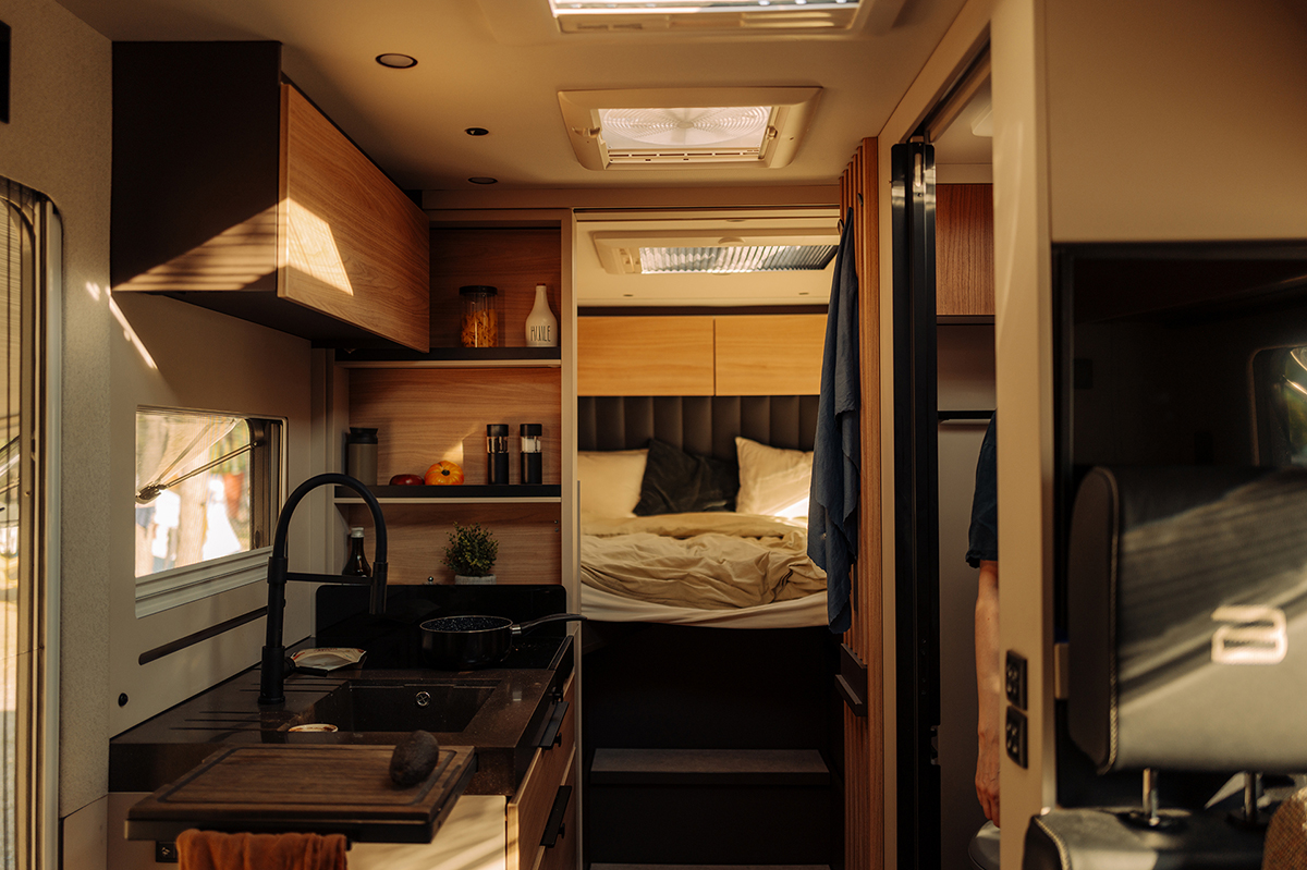 Bürstner Signature Mercedes motorhome interior with kitchen, skylight and bed in warm evening light