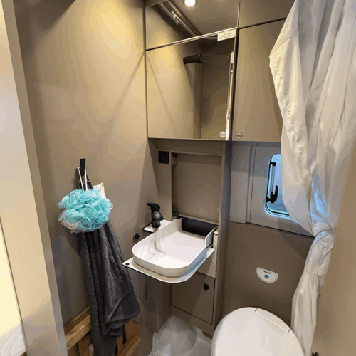 Compact bathroom in the Carado CV595 X-Edition campervan with folding sink, toilet and mirrored cabinet.