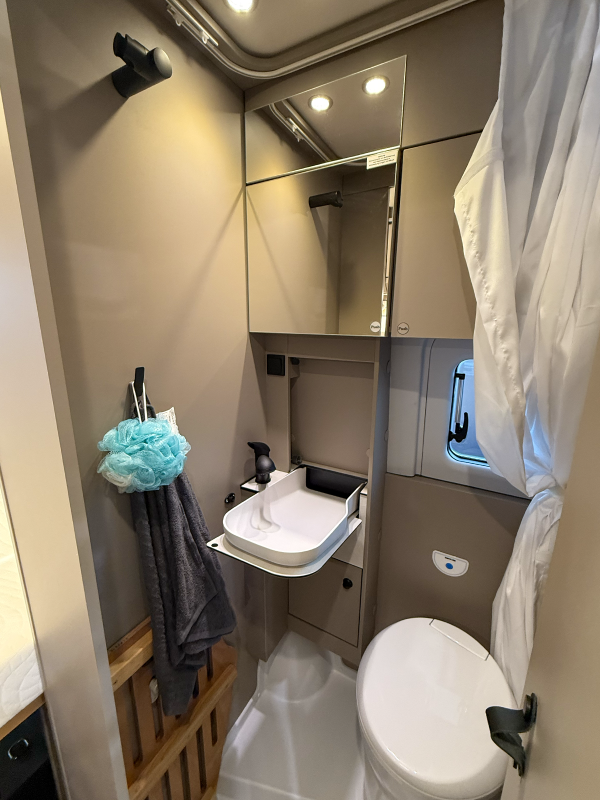 Compact bathroom in the Carado CV595 X-Edition campervan with folding sink, toilet and mirrored cabinet.