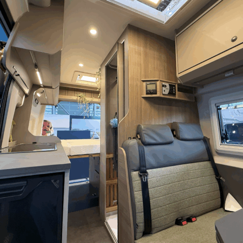 Interior of the Carado CV595 X-Edition campervan showing rear seating, kitchenette and bed area.