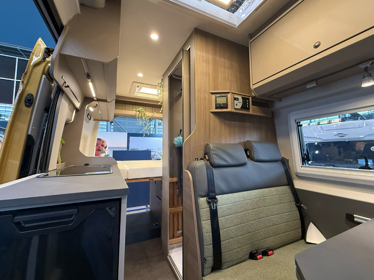 Interior of the Carado CV595 X-Edition campervan showing rear seating, kitchenette and bed area.