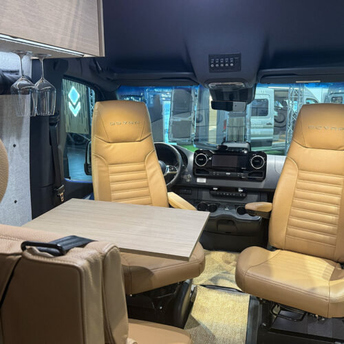 Dovra RIG X-710 motorhome cab with swivelled tan leather captain chairs and fold-out table