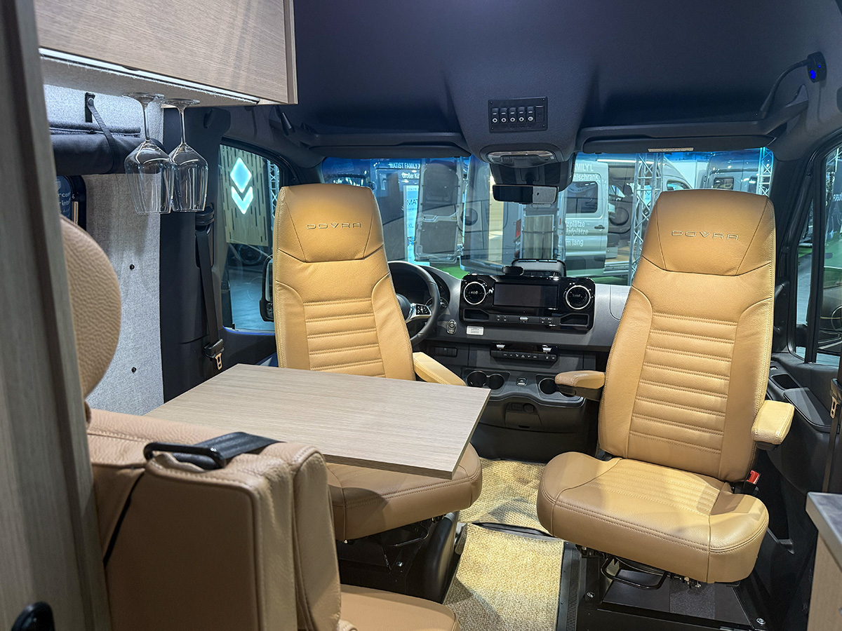 Dovra RIG X-710 motorhome cab with swivelled tan leather captain chairs and fold-out table