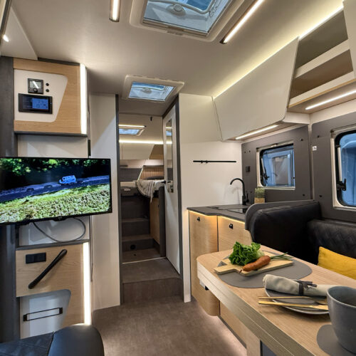 Interior of the Ahorn Camp Eclipse motorhome showing kitchen, dining table and rear bedroom at Caravan Salon 2026