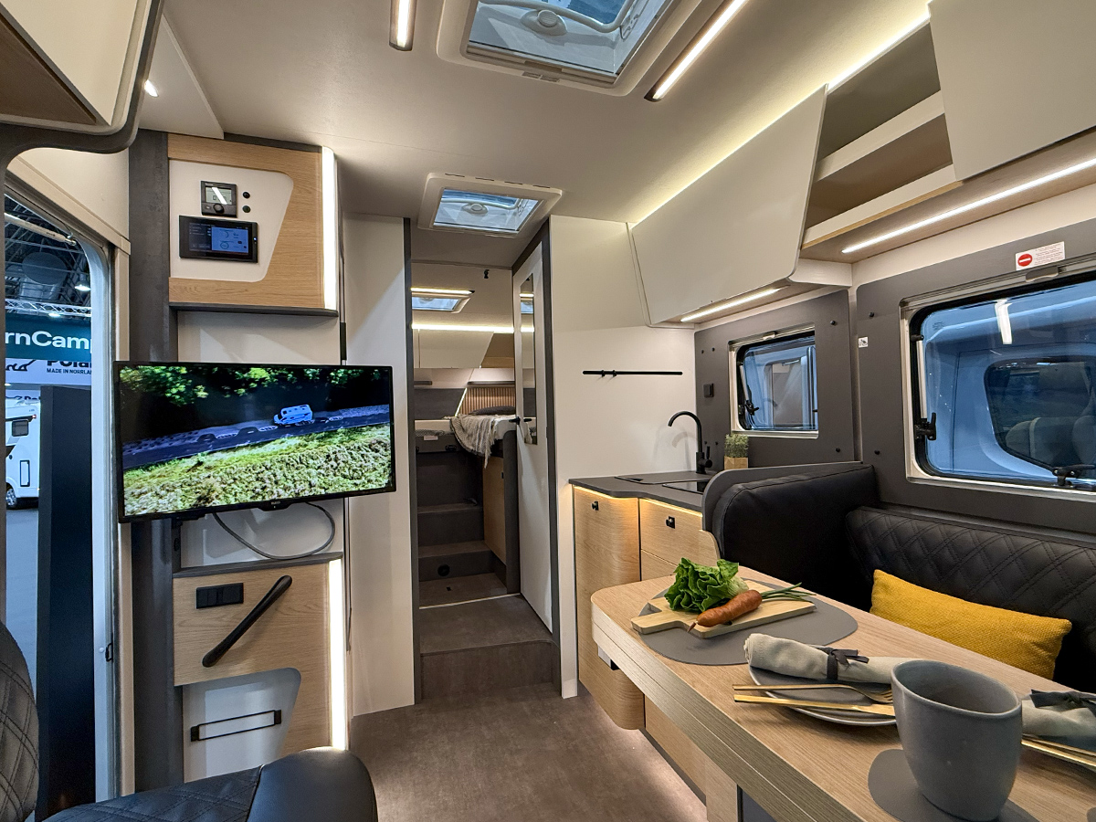 Interior of the Ahorn Camp Eclipse motorhome showing kitchen, dining table and rear bedroom at Caravan Salon 2026