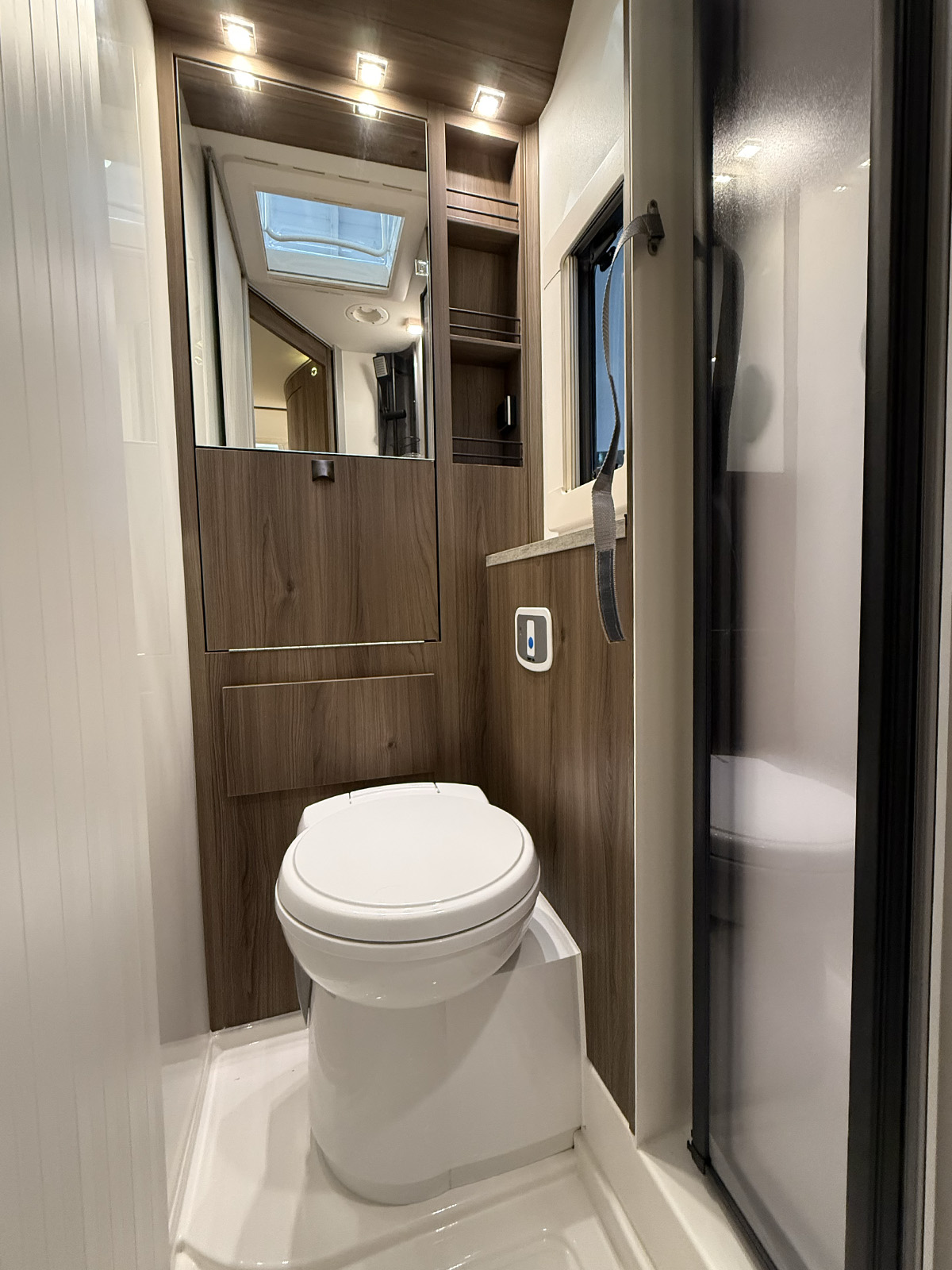 Compact toilet and washroom with wood-finish cabinetry in the Kabe Novum Compact 720 LXL motorhome.