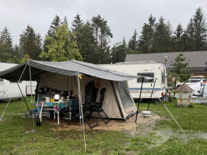 Wet porch tent canopy at campsite after rain, illustrating challenge of packing a wet tent before mould sets in
