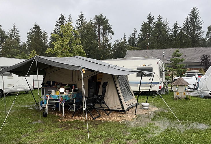 Wet porch tent canopy at campsite after rain, illustrating challenge of packing a wet tent before mould sets in
