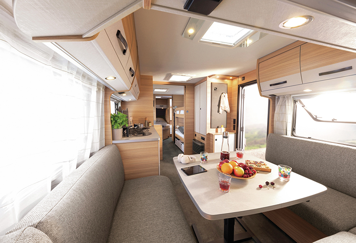 Dethleffs Summer Edition 730 FKR interior with lounge seating, dining table and bunk beds visible at rear